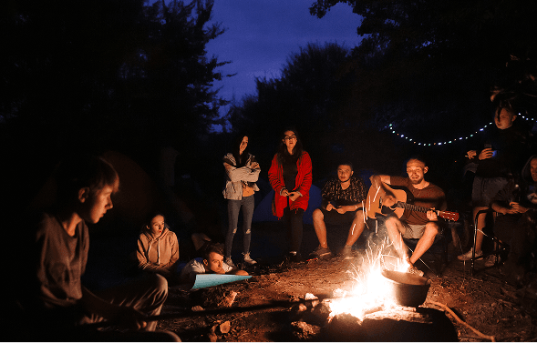 Amigos reunidos alrededor de una fogata